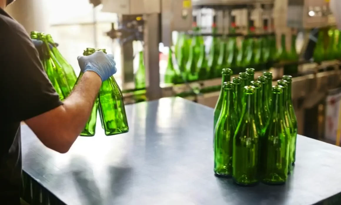 Image of worker handling beverage production line with properly sized tunnel pasteurizer